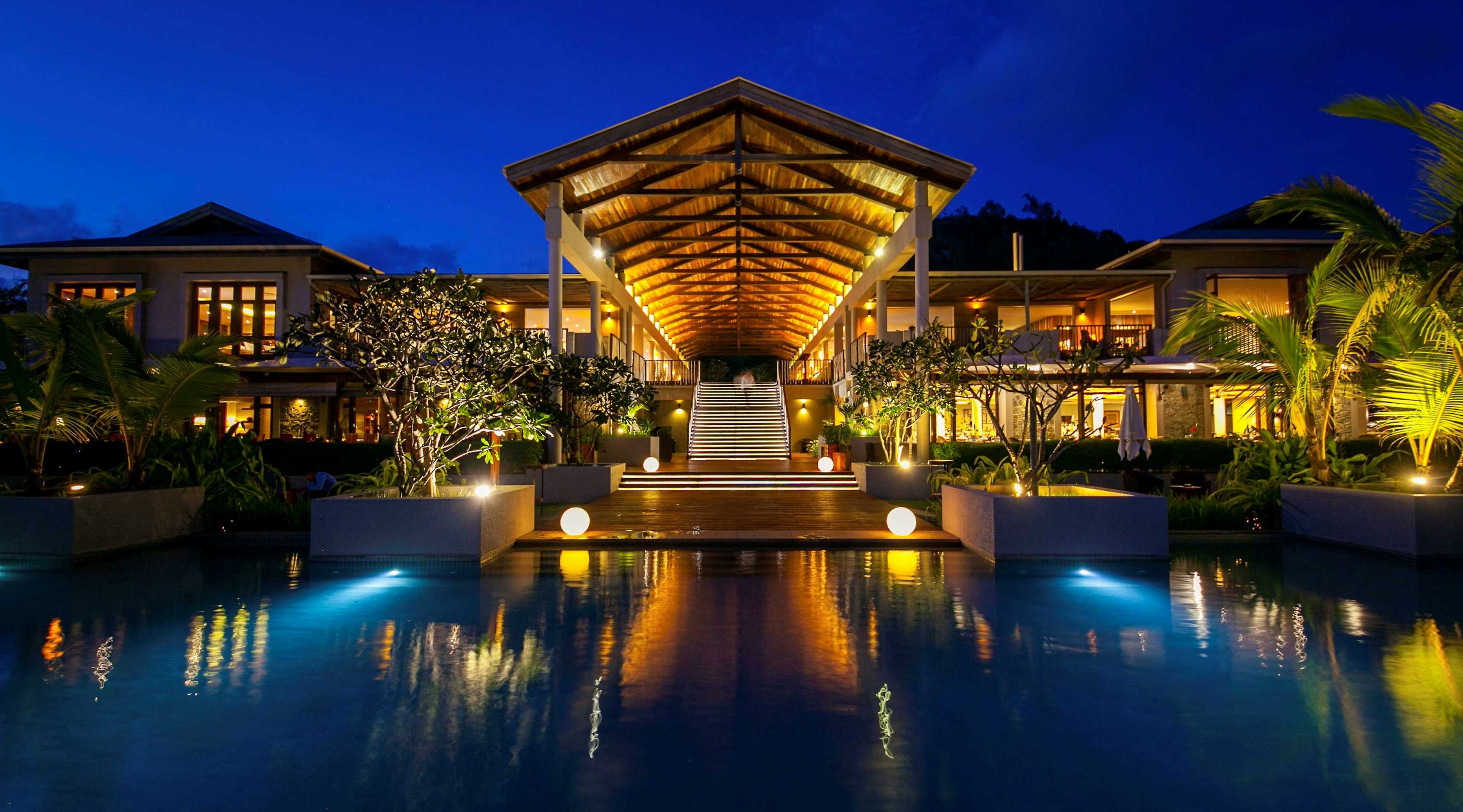 Panorama-Ansicht von luxuriösen Hotels an einem tropischen Strand mit Palmen und türkisfarbenem Wasser