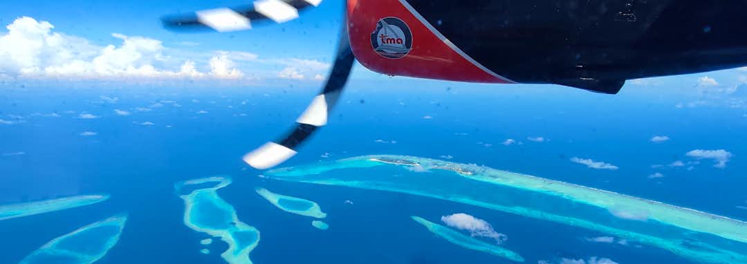 Urlaubsziel Malediven – Luxus-Wasservillen der Malediven über kristallklarem Lagunenwasser bei Sonnenuntergang